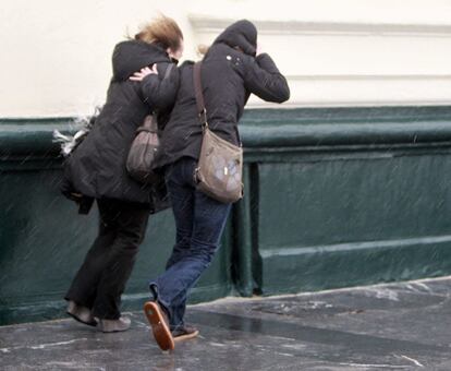 Dos mujeres intentan avanzar pese a la lluvia y el viento hoy en San Sebastián, el 16 de diciembre de 2011.