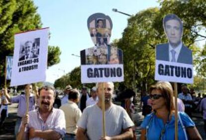 Unos manifestantes sostienen unas pancartas con el retrato del primer ministro de Portugal, Pedro Passos Coelho, en las que se lee la palabra "ladrón", en portugués, en el exterior del palacio de Belem en Lisboa, Portugal, durante una reunión del Consejo de Estado ayer viernes 21 de septiembre de 2012.