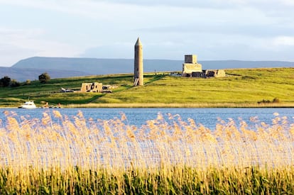 Vista de las ruinas de una torre celta en la isla Devenish, en el Lower Lough Erne (Irlanda del Norte).