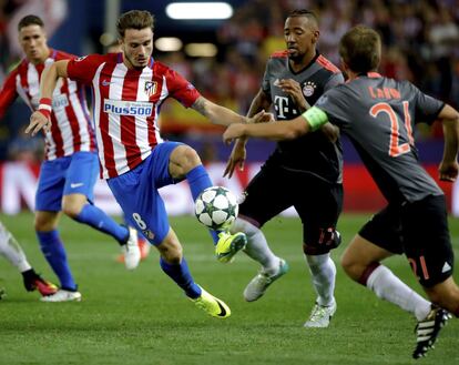 El delantero del Atlético de Madrid Saúl Ñíguez (i) lucha el balón con el defensa Jerome Boateng.