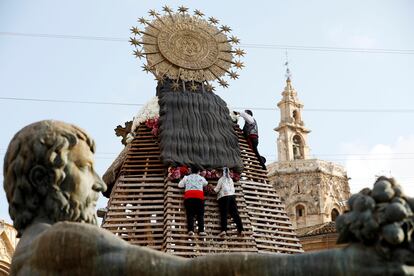 Tres "vestidors" visten con flores el manto de la Virgen de los Desamparados durante la Ofrenda a la Virgen, uno de los actos más emotivos de las Fallas.