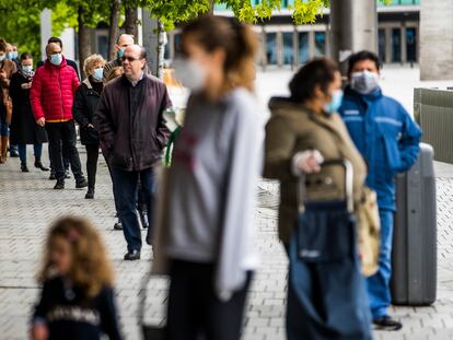 Varias personas esperan para comprar en la plaza de Felipe II de Madrid.