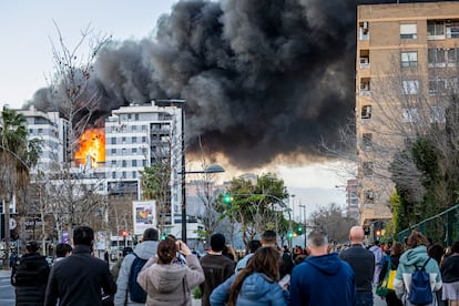 Los vecinos observan el edificio en llamas. 