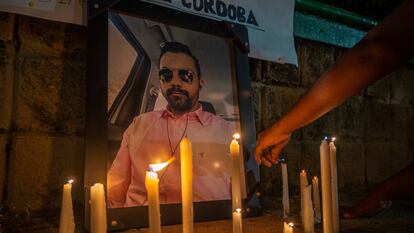 Una persona coloca una vela en honor de periodista asesinado Rafael Moreno.