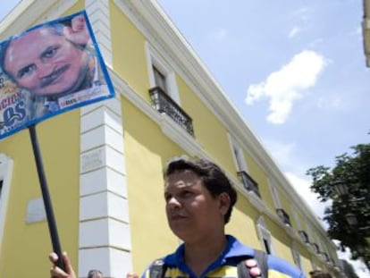 Un manifestante pide la repatriaci&oacute;n de &#039;Carlos&#039; frente al ministerio de Exteriores venezolano, en Caracas.