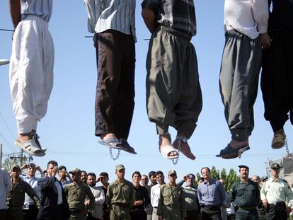 Un grupo de personas observa los cuerpos de cinco ahorcados en Mashad (Irán) el 1 de agosto de 2007. Algunos de los asistentes toman fotos de los ejecutados.