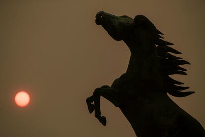 Vista del cielo cubierto de humo, con el sol enrojecido, en la plaza de Espa?a de Vigo.