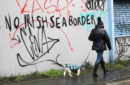 Una mujer camina frente a una pared en la que se lee "Sin frontera del mar de Irlanda", en Belfast el miércoles.