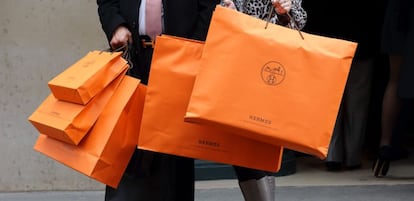 Una pareja con bolsas de una tienda de Hermès en París.