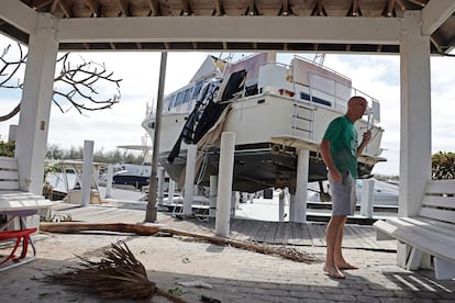 Un hombre habla por teléfono junto a un barco que quedó encallado en el muelle de Puerto Sanibel, cerca de Fort Myers. El presidente de EE UU, Joe Biden, advirtió este jueves de que el huracán Ian puede haber sido el mortífero en la historia de Florida y afirmó que viajará al lugar “cuando las condiciones lo permitan”. 