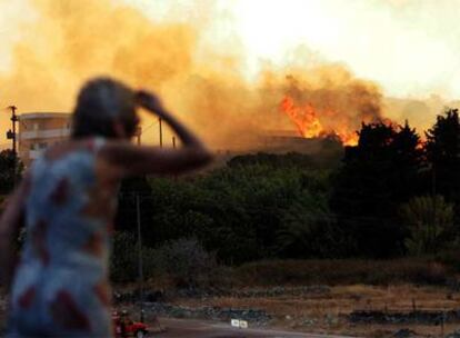 Una mujer contempla en el avance de las llamas en Grecia