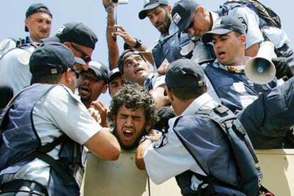 Policías israelíes introducen en un camión a un colono que resistía en la sinagoga de Gadid.