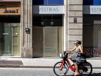 Una dona passa davant de comerços tancats a Barcelona.