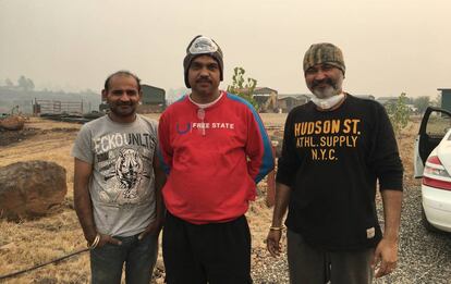 Vishal Mahindru (a la derecha), con su hermano y su cuñado en la finca de Paradise que salvaron del fuego.