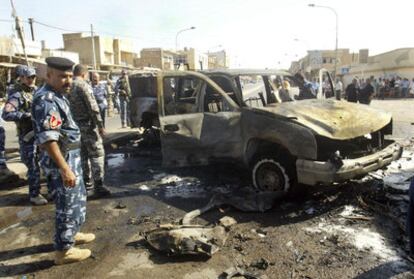 Policías iraquíes inspeccionan el estado en que ha quedado un vehículo en Kirkuk.