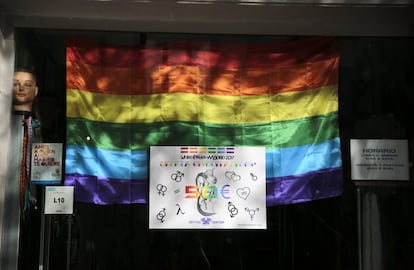 Una bandera del Orgullo Gay dentro de una tienda de tatuajes en Madrid.