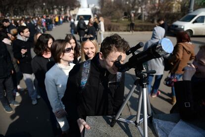 Varias personas hacen fila para mirar por un telescopio en Moscú (Rusia).