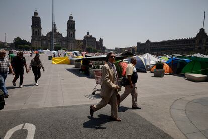 Transeúntes caminan por el Zócalo junto a las tiendas de campaña de los sindicatos magisteriales, el 16 de mayo.