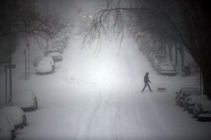 Una persona camina por una calle nevada en Brooklyn en Nueva York (EE UU).