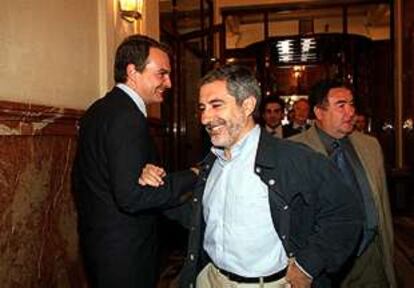 José Luis Rodríguez Zapatero (PSOE) y Gaspar Llamazares (IU) se saludan en los pasillos del Congreso.