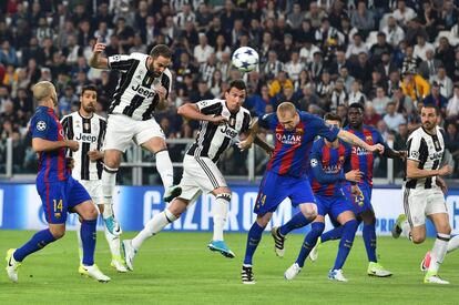 El delantero del Juventus, Gonzalo Higuaín, encabeza la pelota junto al delantero del Juventus, Mario Mandzukic (c) y el defensa Javier Mascherano (i) durante el partido.