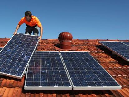 Un t&eacute;cnico instala placas solares en el tejado de una vivienda.