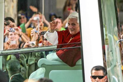 El Papa saluda desde el interior del <i>papamóvil</i> a la multitud que lo aguardaba a su llegada al centro de Madrid.