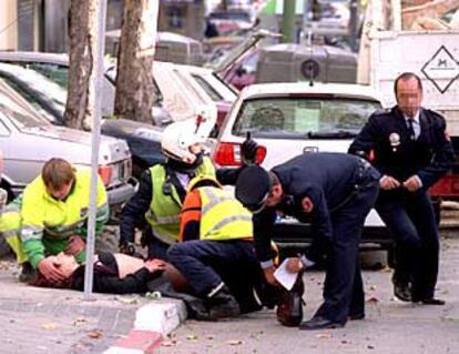 Agentes municipales atienden a una mujer herida por la deflagración del coche bomba.