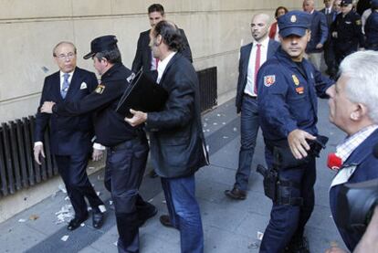 José María Ruiz-Mateos (a la izquierda) es escoltado por la policía a la entrada ayer en la Audiencia Nacional.