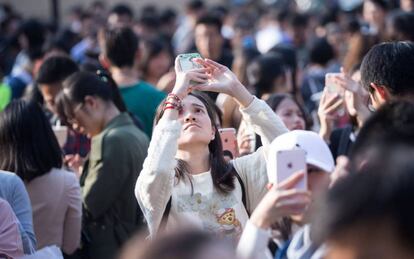 Una joven hace uso de su teléfono móvil en China. Foto de archivo.