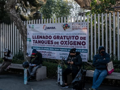 Familiares de enfermos esperan formados un  turno para poder recargar sus tanques de oxigeno en la explanada de la delegación de Iztapalapa.