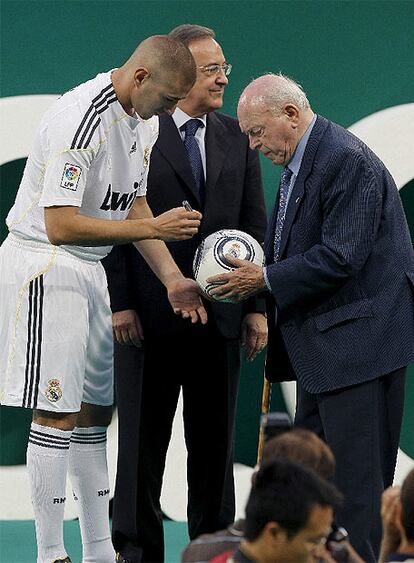 Benzema firma un balón sostenido por Di Estéfano ante la presencia de Florentino Pérez