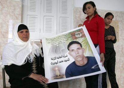 Manoubia Bouazizi y sus hijas muestran un cartel de Mohamed.