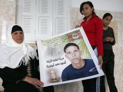 Manoubia Bouazizi y sus hijas muestran un cartel de Mohamed.