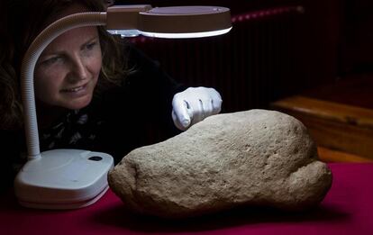 La investigadora d'ICREA, Inés Domingo, amb la pedra que conté la peça d'art paleolític.