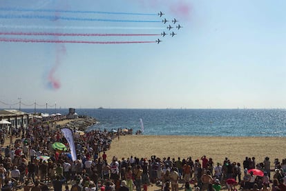 Cientos de espectadores observan el espectáculo aéreo de la Patrouille de France en la playa barcelonesa de la Mar Bella.