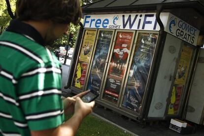 Un usuario busca wifi al lado de un quiosco en el paseo de la Castellana en una imagen de archivo.