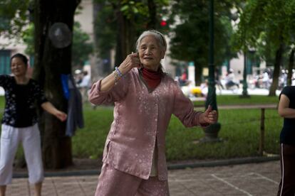 Un grupo de mujeres hace ejercico en un parque arbolado de Hanoi (Vietnam).