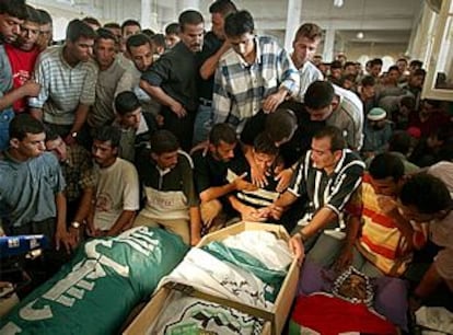 Varios palestinos velan los cadáveres de sus familiares muertos en la incursión del Ejército de Israel en un campo de refugiados de Gaza.