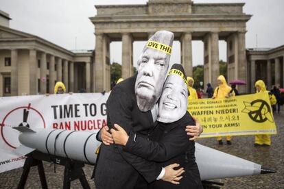 Dos activistas con máscaras de Donald Trump y Kim Jong-un se abrazan durante una protesta antinuclear, en Berlín (Alemania).