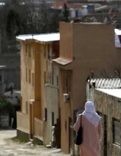 Una mujer camina por una calle de la Cañada Real Galiana.