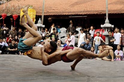 Dos hombres compiten durante un festival de lucha en la localidad Mai Dong en el distrito de Hoang en Hanoi (Vietnam).