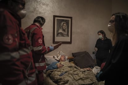 <p><b>Dolor puerta a puerta</b><p/> En marzo, la rica provincia de Bérgamo, en Italia, se convirtió en el epicentro de la pandemia en el mundo. El reportaje del que forma parte esta fotografía documentó para The New York Times la tremenda dimensión de la tragedia. En la imagen, miembros de la Cruz Roja atienden a Claudio Travelli, un conductor de 60 años, antes de evacuarle al hospital.<br><br><i>“Pensé en cómo poner caras a los números y retratar desde dentro la peligrosidad del virus. En Italia solo se publicaban fotos de calles vacías. Lo preparé durante días, visualmente también, así es como trabajo. Luego cuando fotografías hay que ser empático, construir relaciones humanas, y eso se refleja en las fotos”.</i><br>