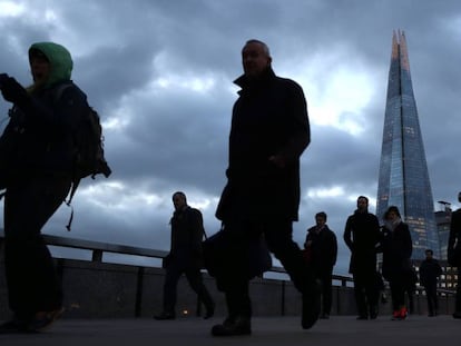 Varias personas caminan ayer por el distrito financiero de Londres. 