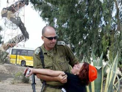 Un militar israelí ayuda en Gush Katif a una mujer que se ha desmayado.
