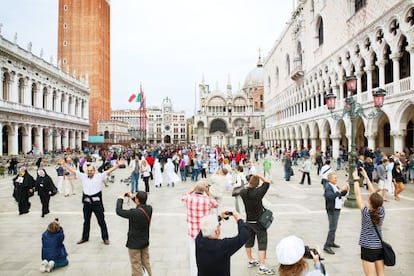 Turistas haciendo fotos en la plaza de San Marcos de Venecia.