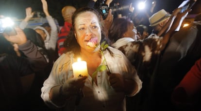 Un grupo de personas canta a las afueras de las casa de Mandela.