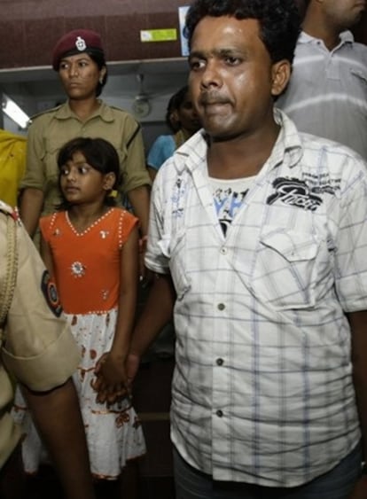 El padre de Rubina Ali, Rafiq Qureshi, sale con su hija de la estación de policía donde se declaró inocente de querer venderla.