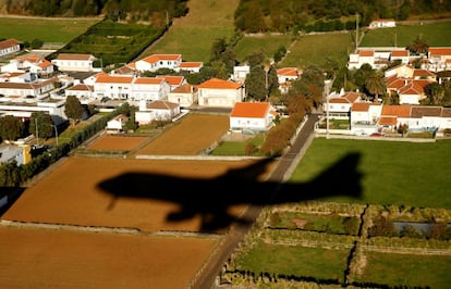 La sombra del Air Force One se proyecta sobre las casas, antes de aterrizar para reabastecerse de combustible en la base aérea de Lajes en las Azores, Portugal, el 18 de Noviembre de 2016.