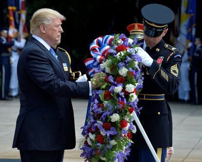 El presidente de EE UU Donald Trump deposita una corona de flores junto a un soldado en el Día de los caídos en el Cementerio de Arlington en Washington.